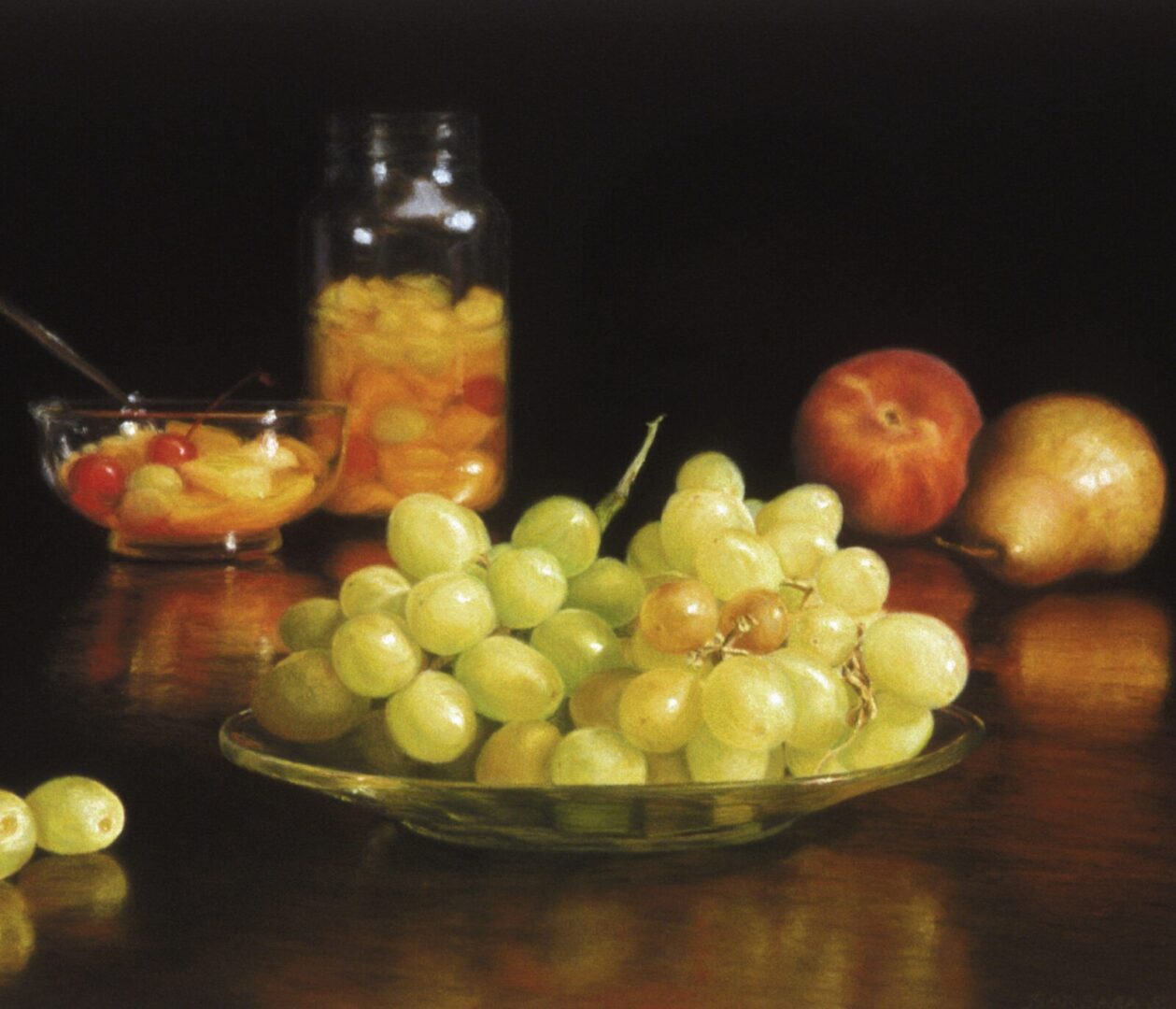 A glass bowl of grapes on a table.