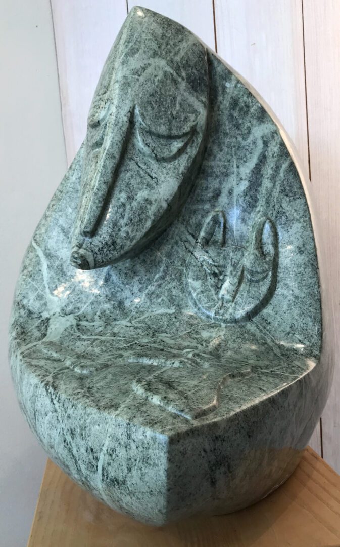 A green marble sculpture with a face on it.