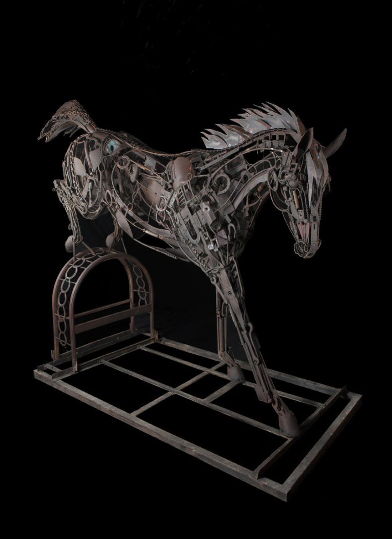 A metal sculpture of a horse standing on a platform.