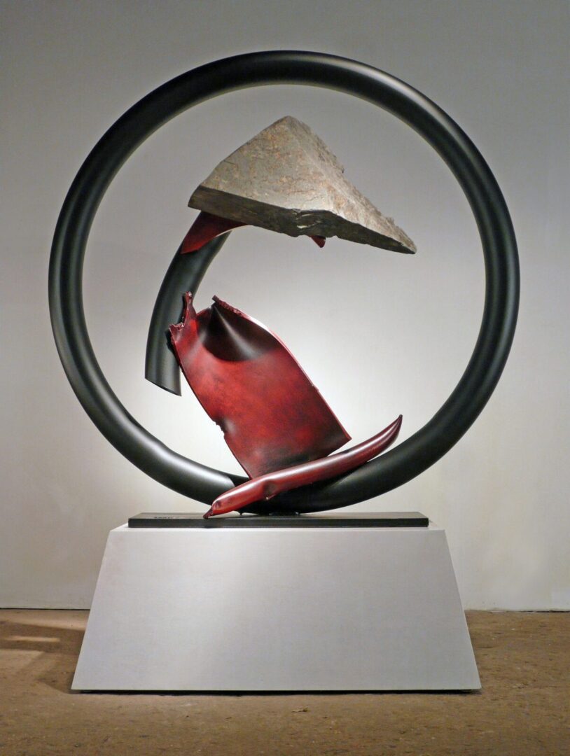 A red and black sculpture on a pedestal.
