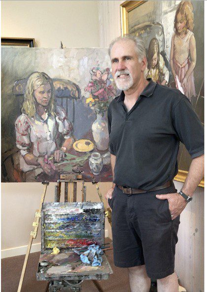 A man standing in front of a painting easel.